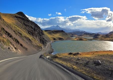 A trip at high speed  Dangerous driving in the national park Torres del Paine, Chile  A gravel road runs by the lakesideの写真素材