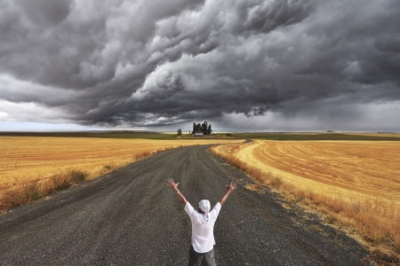 The enthusiastic tourist welcomes thunderstorm above Montana. Fields after a harvest and roadの写真素材