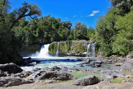 Picturesque cascading waterfall among rocks and forestsの写真素材