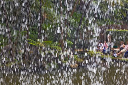 Picturesque cascading waterfall in a tropical park. The picture was taken through the waterの写真素材