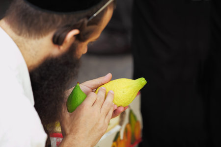 BNEI-BRAK, ISRAEL - SEPTEMBER 22: The religious Jews in a hat are choosing ritual plant citron at the market on the eve of Sukkot September 22, 2010 in Bnei Brak, Israel. This was Sukkoth marketのeditorial素材