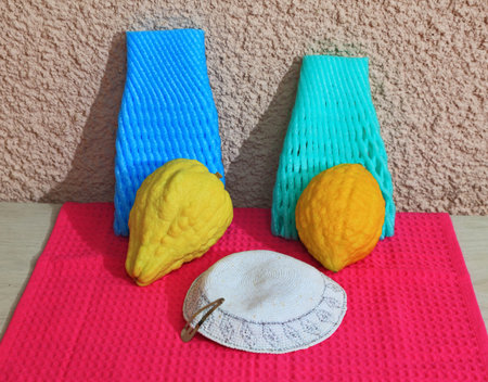 Autumn Jewish holiday of Sukkot. White skullcap and two ritual etrog on bright crimson background