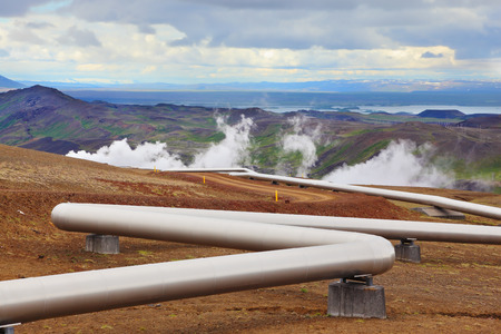 Pipeline to transport hot water. Summer Iceland. Krafla Lake neighborhood. Steam rises above the hot groundの写真素材