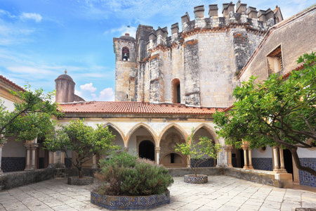 The imposing medieval castle - the monastery of the Templars. Cozy internal court yard with gallery. In the center a stone round bed.のeditorial素材