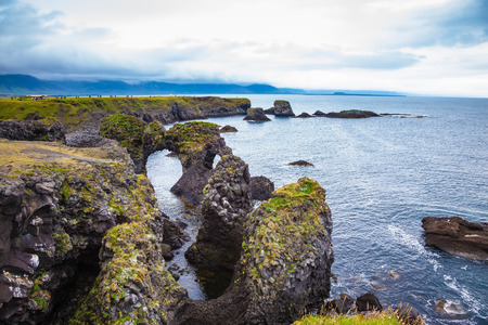Magical coastal cliffs fishing village Arnastapi. July day in Icelandの写真素材