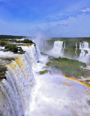 White whipped foam of water and a thin mist over the water.  Magnificent rainbow shines in the mist. The most high-water waterfall in the world - Iguazu. The picture is taken by lens Fisheyeの写真素材