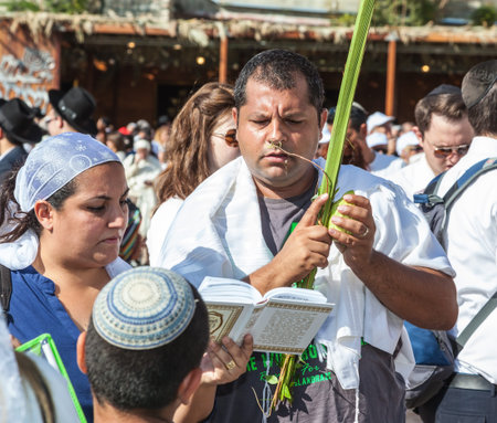 JERUSALEM, ISRAEL - OCTOBER 12, 2014: The area in front of Western Wall of Temple filled with people.  Many believers have brought prayer books and four ritual plants. Morning autumn Sukkotのeditorial素材