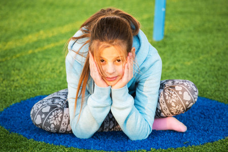 Family children's party. Beautiful teenage girl is engaged in yoga on the playground