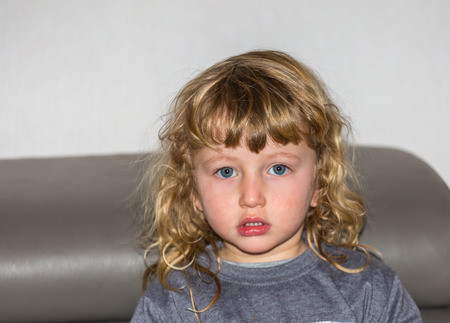 Beautiful little boy with blue eyes and  golden curlsの写真素材