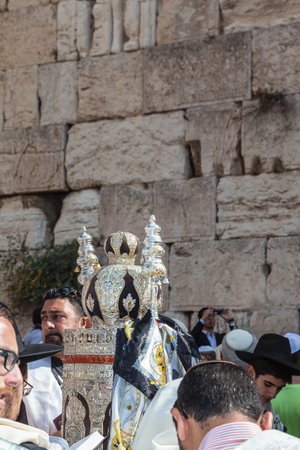 JERUSALEM, ISRAEL - OCTOBER 12, 2014: Morning autumn Sukkot. The area in front of Western Wall of  Temple. Crowd of Jewish worshipers in white wearing prayer shawls. On table there is Torah Roll in magnificent caseのeditorial素材