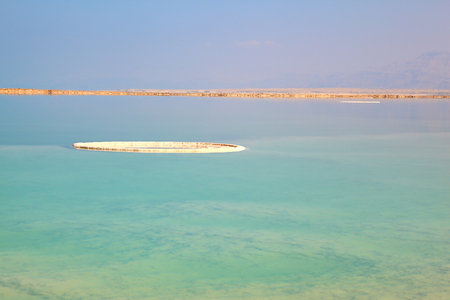 The shoaled Dead Sea at coast of Israel. The condensed salt out over water surfaceの写真素材