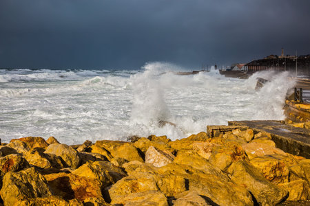 Huge foaming waves beating against the shore. Strong storm in the Mediterranean Sea. New Quay in the...