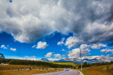 The magnificent Canadian highway among evergreen forests and snow mountainsの写真素材