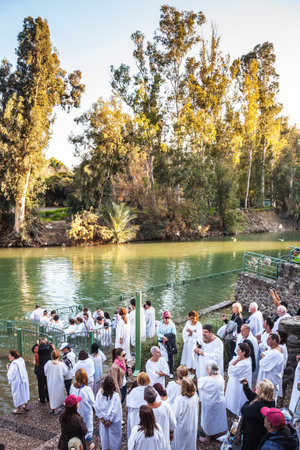 YARDENIT, ISRAEL - JANUARY 21, 2012: Christian pilgrims make  baptism ceremony in honor of Jesus Christ's baptism here.  They enter Jordan River watersのeditorial素材