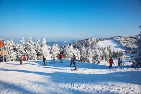 SKI CENTER KOHUTKA, CZECH REPUBLIC - JANUARY 16, 2010: Ski resort in the Czech Tatra. Frosty sunny winter day. Skiers in bright jackets are preparing to skiingのeditorial素材