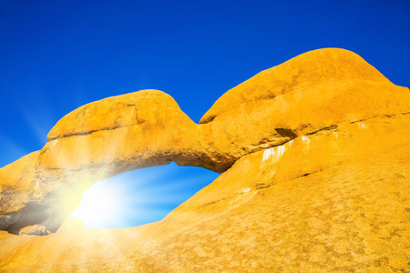The concept of extreme and ecological tourism. Natural array of bald granite outcrops and stone arch Spitzkoppe, Namibia. The hot African sun over the Namib Desertの写真素材