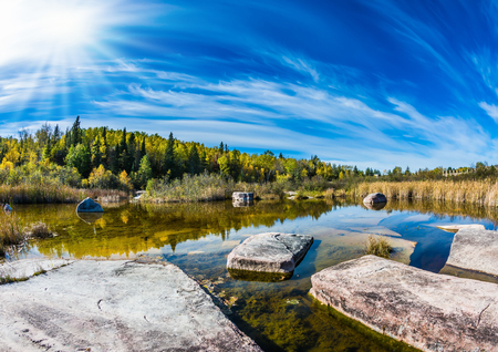 Huge flat stones in riiverbed of Winnipeg River. Old Pinawa Dam Park. Indian summer in Manitoba, Canada. The concept of recreational tourismの写真素材