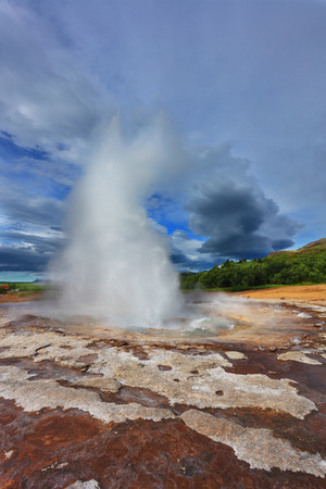Gushing geyser Strokkur. High column of hot water and steam from the crater of the geyser. Iceland in the summerの写真素材
