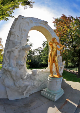 Elegant gilded statue of Johann Strauss, playing the violin in white marble arch. Park in Viennaのeditorial素材