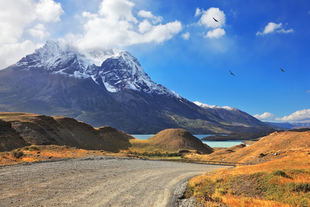 Dreamland Patagonia. Snow-capped mountain peaks, the lake and the gravel roadの写真素材
