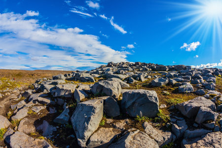 Huge stones on the plateau near a waterfall Dettifoss lit by sunset lightの写真素材