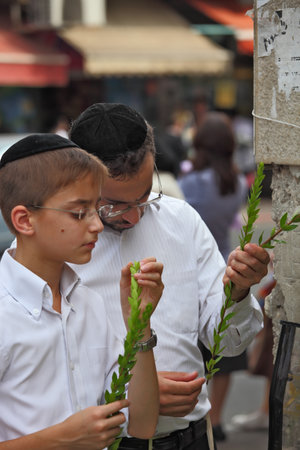 Bnei Brak - September 22: The group of Jewish boys in velvet skullcaps chooses ritual plant  before the holiday of Sukkot. Holiday city market September 22, 2010 in Bnei Brak, Israelのeditorial素材