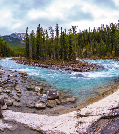 Small island in the middle of the river. Jasper National Park, Canada. The concept of extreme and ecological tourism. The waterfall rushes to the rocky shoresの写真素材