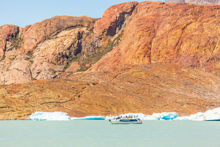 Unique lake Viedma in Patagonia. The enormous glacier sliding into the lake. From the edge of the glacier break off huge blue floes. Pleasure tourist boat floats to the glacierのeditorial素材