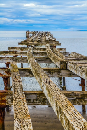 Rusted and destroyed remains of the sea mooring. South of South America. The legendary Strait of Magellan. Cloudy autumn morning. The concept of extreme and active tourismの写真素材