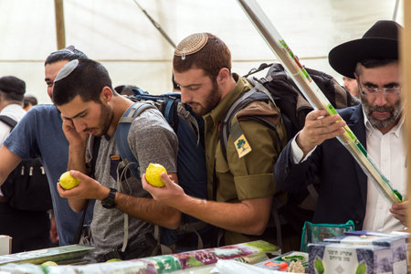 ERUSALEM, ISRAEL - OKTOBER 16, 2016: Traditional market before the holiday of Sukkot. Young men - Jews in knitted skullcaps choose etrog at a counterのeditorial素材