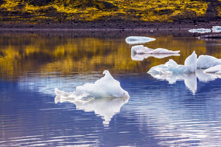Summer in Iceland. The concept of extreme northern tourism. The cold lake with splinters of ice...