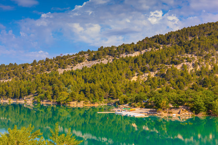 Smooth water of the river reflects the wooded shore and cloudy sky. Europe's largest alpine canyon Verdonの写真素材