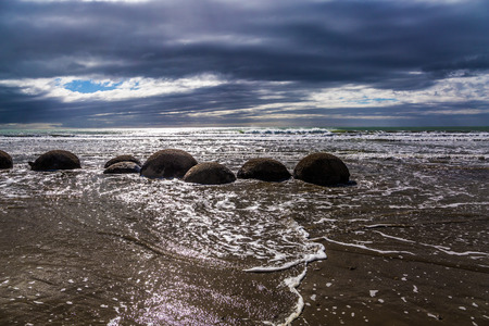 Boulders Moeraki - a group of large spherical boulders on the beach Koekokhe. Ocean evening tide. Travel to New Zealand. The concept of active, eco and photo tourismの写真素材