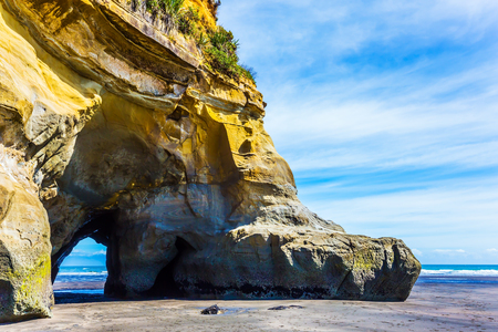 The Pacific coast,  New Zealand, North Island. Powerful coastal arches and rocks to the ocean tide. The concept of active and phototourismの写真素材