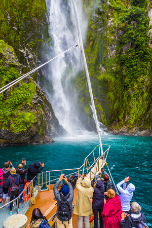 Powerful waterfall from the steep bank of the fjord Milford Sound. Passengers photograph the waterfall. The best journey in life. Concept of active and ecological tourism
の写真素材