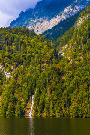Koenigssee - the cleanest lake in Germany. The lake is surrounded by mountains. Picturesque forest waterfalls and steep shores of the lake. The concept of active, ecological and photo tourismの写真素材