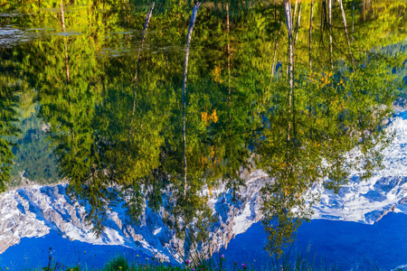 The mountain resort of Chamonix. City Park is illuminated by the sunset. The lake reflected the evergreen spruce and snow-capped Alps. Concept of active and ecological tourismの写真素材