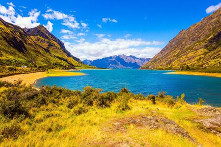 Great trip to a fabulous country. Huge Hawea Lake with turquoise smooth water. The steep slopes of the mountains descend into cold water. The concept of ecological, active and photo tourismの写真素材
