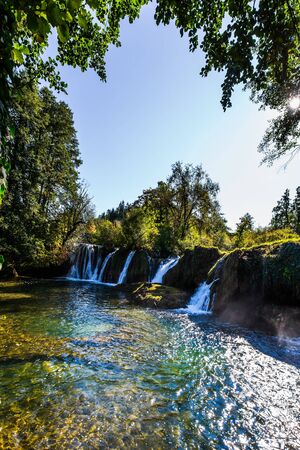The small Croatian town of Slunj. Dense forests surround the city and the river. Magnificent cascade of waterfalls on the Korana River. The concept of ecological, active and photo tourismの写真素材