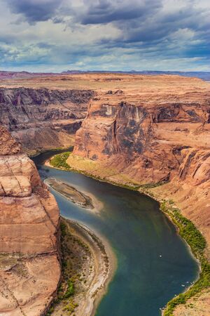 Horseshoe - the landmark of Arizona. Scenic horseshoe-shaped bend of the Colorado River. Red sandstone soil and emerald water create a great contrast. The concept of active and photo tourismの写真素材