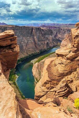Red sandstone soil and emerald water create a great contrast. Horseshoe - the landmark of Arizona. Scenic horseshoe-shaped bend of the Colorado River. The concept of active and photo tourismの写真素材