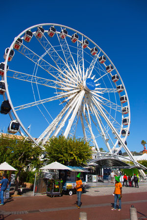 CAPE TOWN, SOUTH AFRICA - APRIL 24, 2016: Great Ferris Wheel. Beautiful sunny day on the ocean shore. Amusement Park in Cape Town Port. The concept of active, exotic and photo tourismのeditorial素材