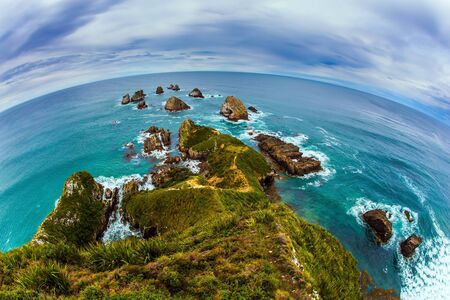The picturesque coast of the Pacific Ocean near Nugget Points. Big stones - rocks along the shore. Photo taken by Fish Eye lens. New Zealand. The concept of active, environmental and photo tourismの写真素材