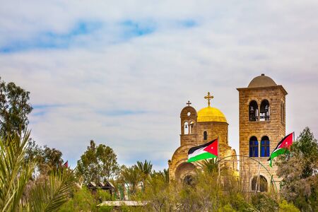 Qasr el-Yahud is the site of the baptism of Jesus Christ by John the Baptist on the West Bank. Church of John the Baptist. Jordanian national flags fluttering on Jordanian side. The concept of pilgrimageの写真素材