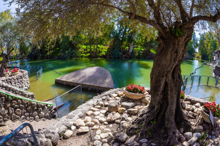 The riverbank is planted with trees and decorated with flowers.Yardenit, Israel. The venue of the symbolic ceremony of baptism for believers of the Greek Orthodox Church and Catholics. Wonderful sunny winter dayのeditorial素材