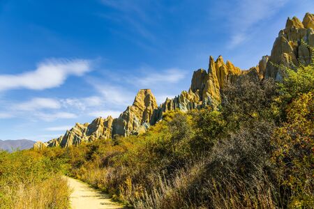 New Zealand, South Island. Ridges of the Clay Cliffs separated by narrow ravines. Dirt path passes around majestic clay cliffs. The concept of exotic, extreme, natural and photo tourismの写真素材