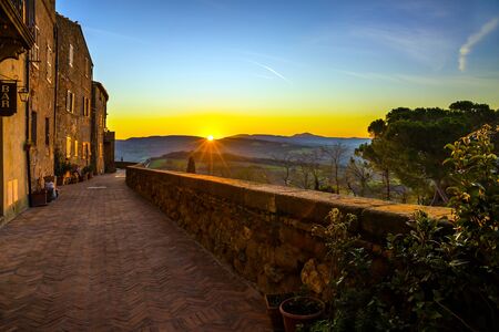 The early dawn. The stunning landscape of the valley is photographed from a protective wall around the city. Tuscany. The concept of active, architectural and photo tourismの写真素材