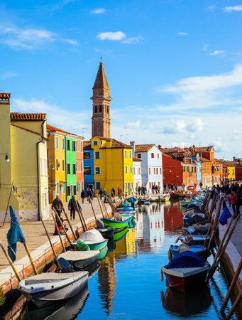 Inclined tower - landmark of the island of Burano. Boats are parked along the banks of the canals. Burano is island of multi colored houses near Venice. The concept of cultural and photo tourismのeditorial素材