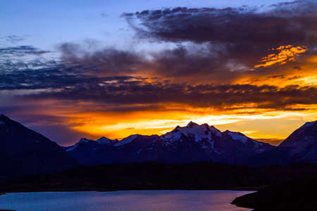 Orange sunset in Patagonia. Los Glaciares Natural Park is the most beautiful in Argentina. Huge lake and mountains. The concept of active, extreme and photo tourismの写真素材
