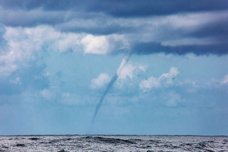 The rarest phenomenon off the coast of Israel - the sea tornado. Raging storm in the Mediterranean Sea. Embankment in Tel Aviv. Sunset. Windy cloudy day in Israelの写真素材